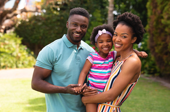 A cheerful family of three stands together outdoors, symbolizing the security and peace of mind a power of attorney can provide.