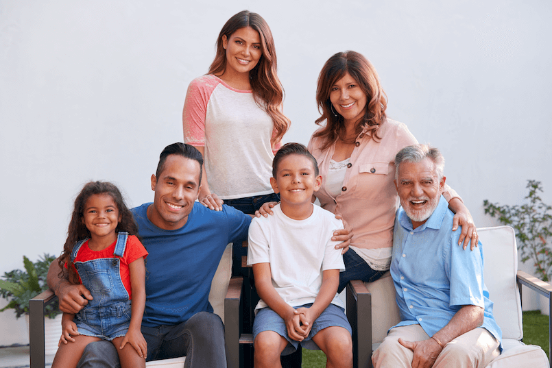 A joyful, multi-generational family of six poses together, embodying the unity and thoughtful planning involved in selecting a power of attorney.
